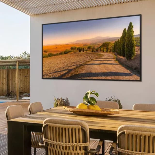 Samsung Frame TV mounted on a wall above an outdoor dining area